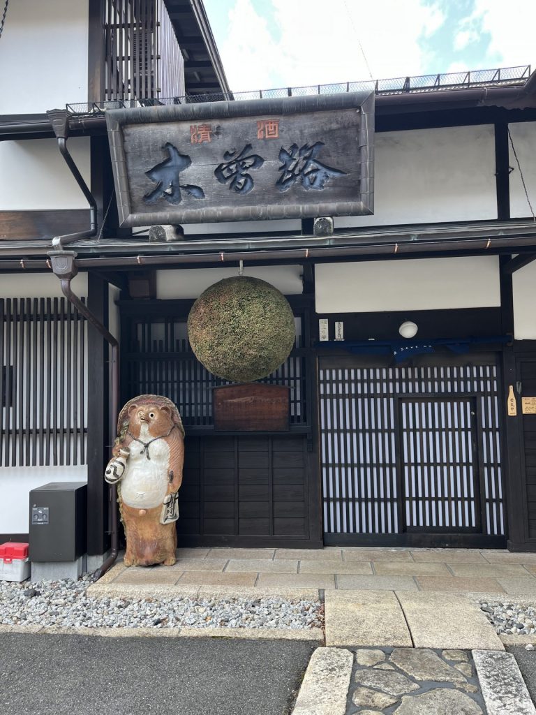 ein alter japanischer Eingang mit einer Tanuki-Statue